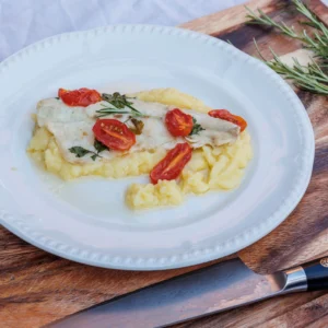 Seabass fillet with cherry tomatoes, wine & herbs served on saffron mash
